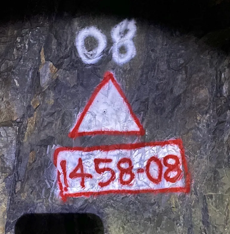 Survey control station 1458-08 spray-painted on an underground mine wall